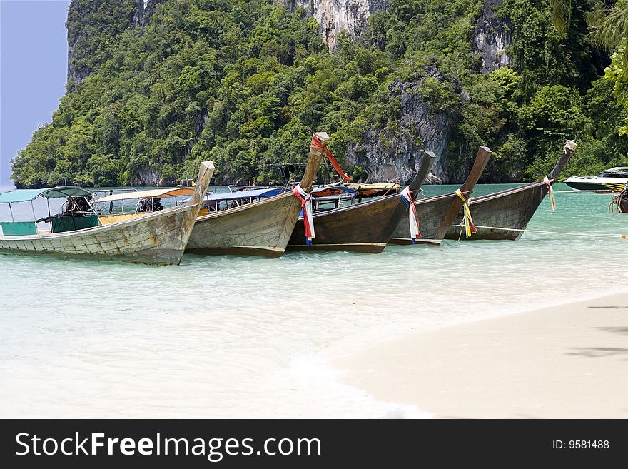 Five wooden boats on the beach of a beautiful island