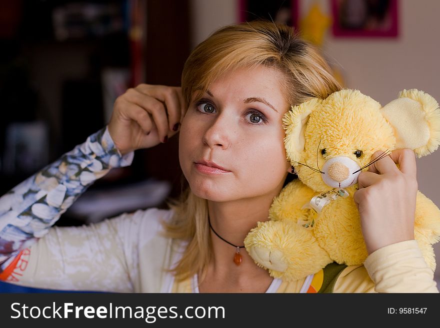 A girl holds a yellow toy-bear. A girl holds a yellow toy-bear