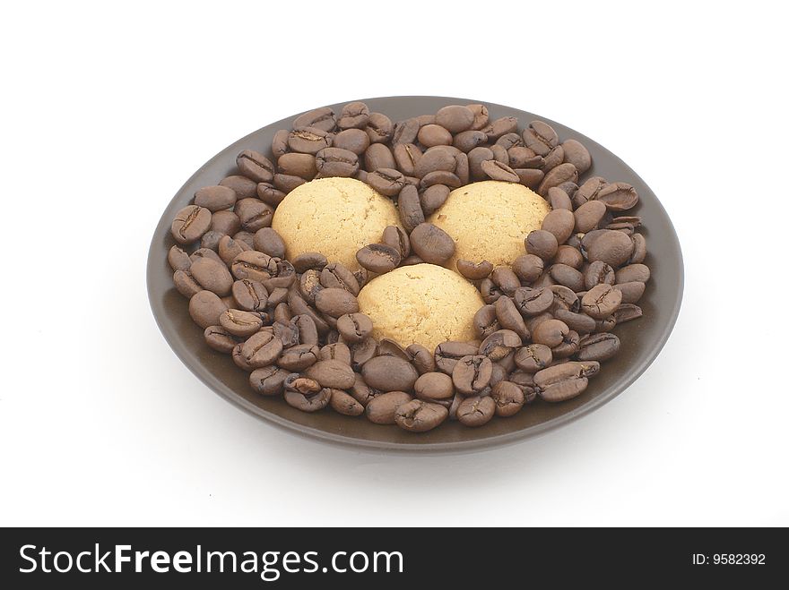 Brown saucer with three biscuits and coffee beans. Brown saucer with three biscuits and coffee beans