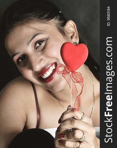 Girl with heart posing in studio.