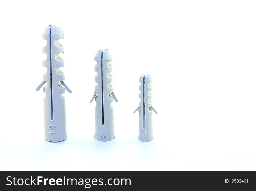 Three different size grey wall plugs on a white background. Three different size grey wall plugs on a white background