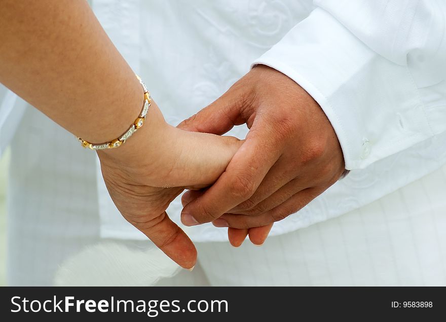 A couple holding hands at the wedding. A couple holding hands at the wedding