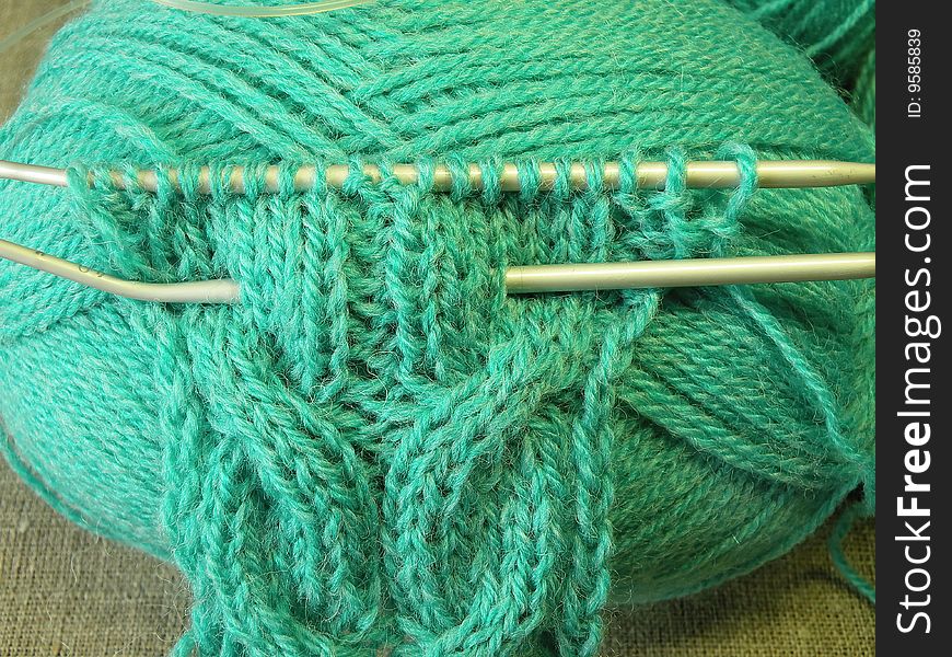 Threads, green knitting and needle