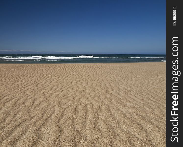 The wind produces a relief on the sand of this desert beach. The wind produces a relief on the sand of this desert beach.
