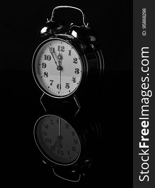 Close up of vintage analog alarm clock on black with reflection. Close up of vintage analog alarm clock on black with reflection.
