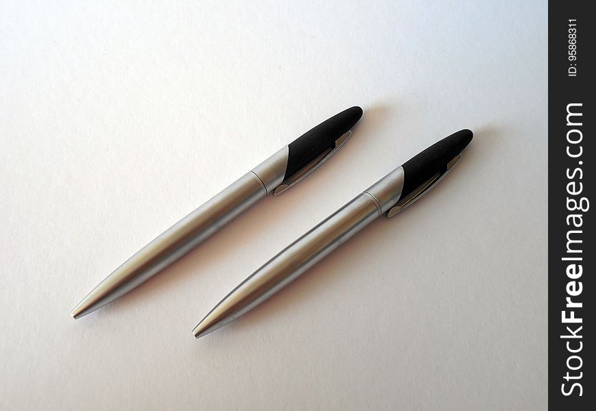 Close up of chrome pen set on white.