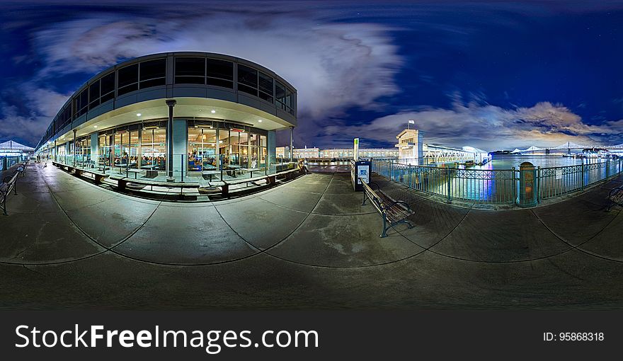 Illuminated glass windows on building along waterfront at night. Illuminated glass windows on building along waterfront at night.