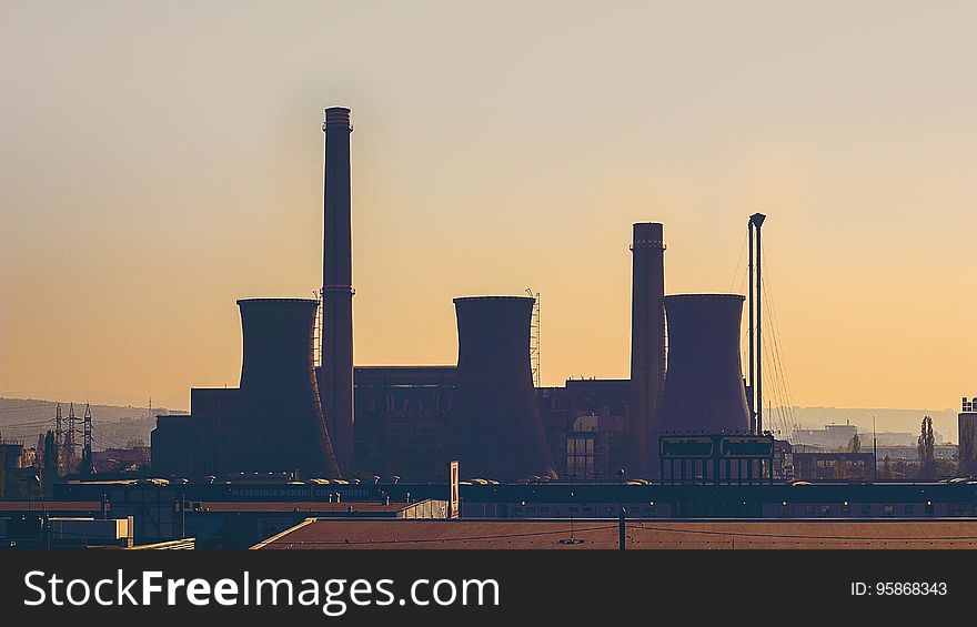 An industrial power plant at sunset.