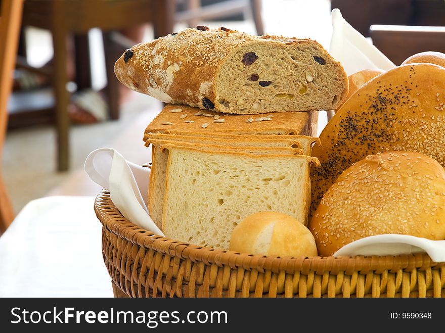 A variety of freshly baked breads served in a basket in a restaurant. A variety of freshly baked breads served in a basket in a restaurant