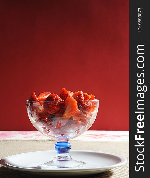 Cup of strawberries on red background