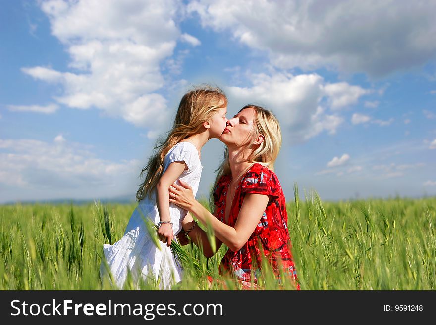 Mother and daughter in green field