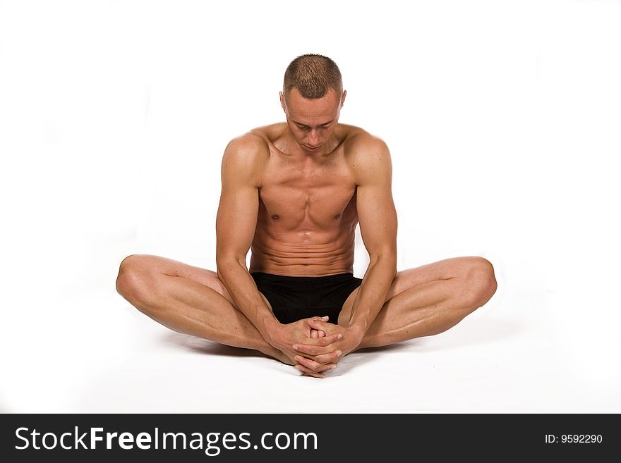 Young sportsman stretching on the white background