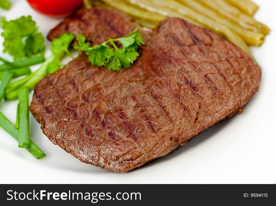 Fresh sirloin strip steak with vegetables.