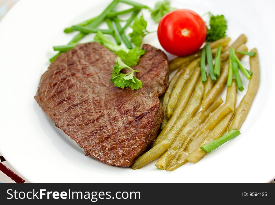 Fresh sirloin strip steak with vegetables.