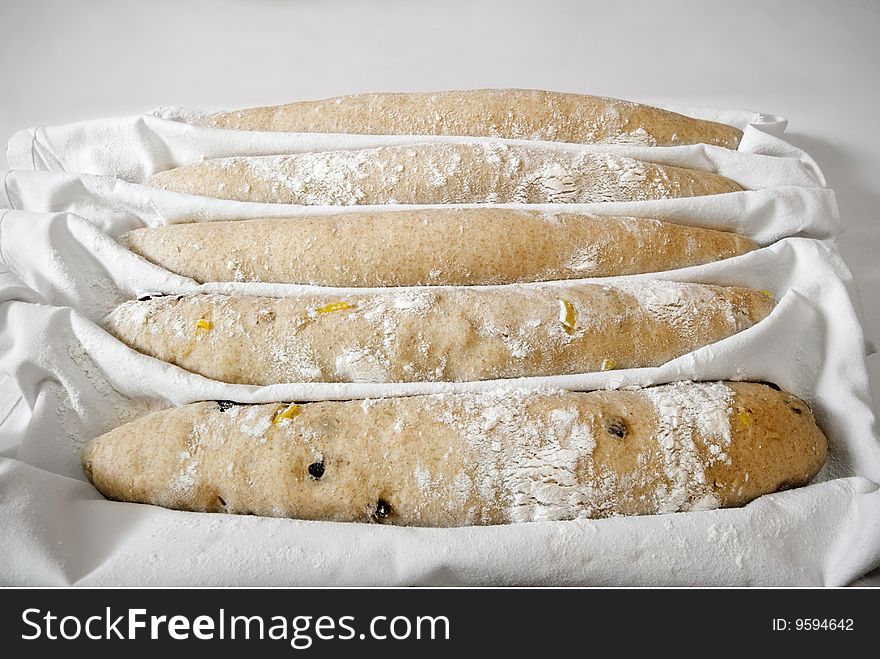 Five baguettes ready for the oven in a restaurant kitchen