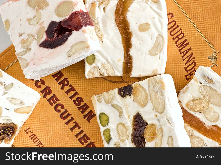 Close-up pieces of sliced delicious nougat from Cassis. Retro-styled background. Close-up pieces of sliced delicious nougat from Cassis. Retro-styled background.