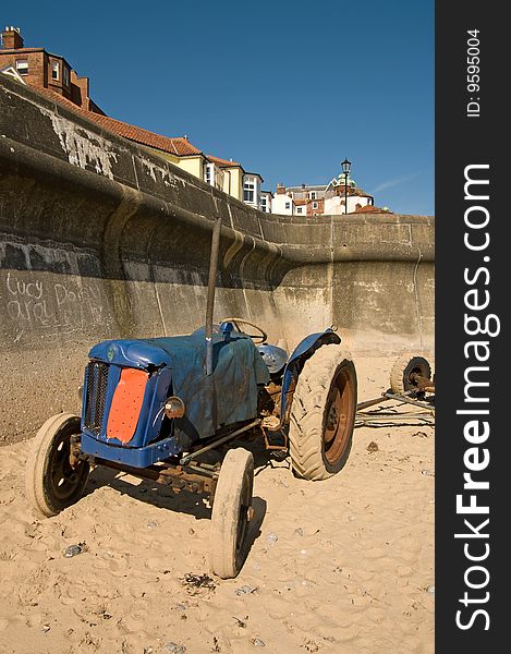 A blue tractor parked on Cromer beach Norfolk. A blue tractor parked on Cromer beach Norfolk