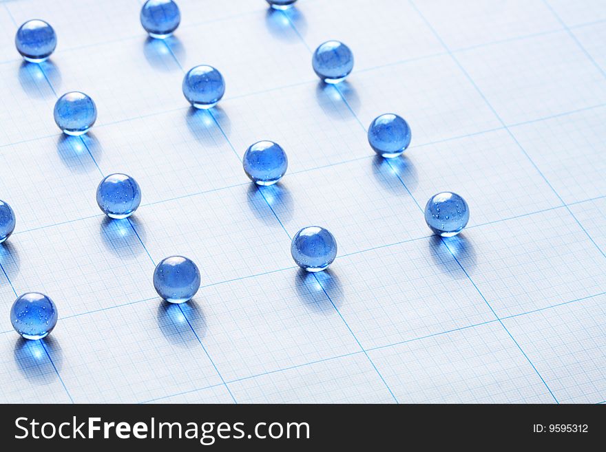 Background made from blue glass balls lying on squared paper