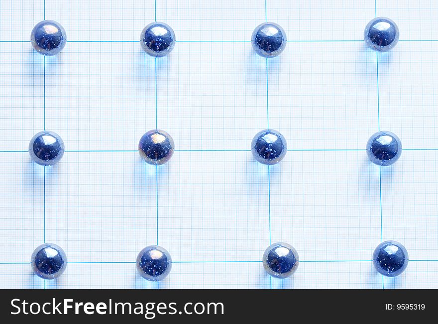 Background made from blue glass balls lying on squared paper