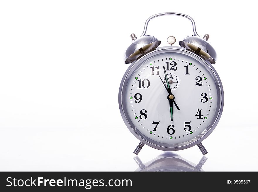 Vintage dusty alarm clock against a white background