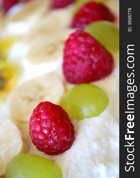 Birthday cake with raspberries, grapes and bananas