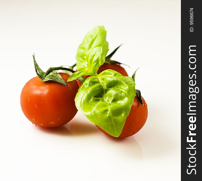 Cherry tomatoes with fresh basil isolated on white. Cherry tomatoes with fresh basil isolated on white