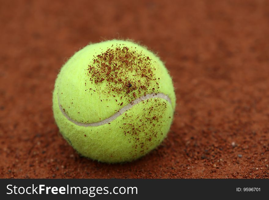 Tennis ball on a red ground