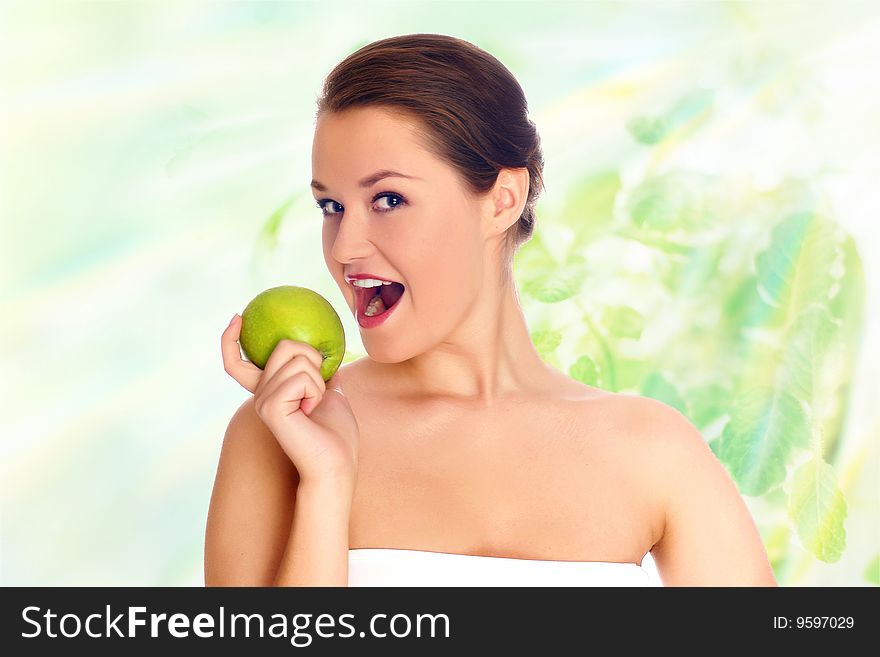 Young woman eating apple and smile over green background