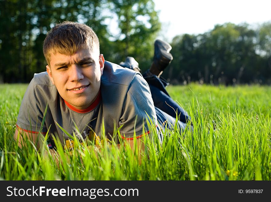 Young man lying down of grass. Copy space. Young man lying down of grass. Copy space