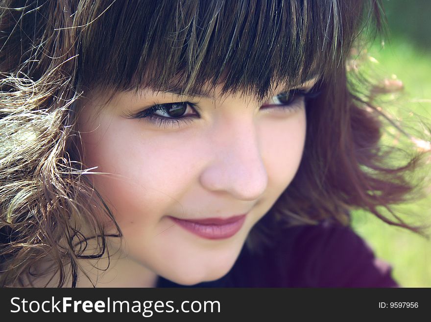 Smiling  sly girl and green grass