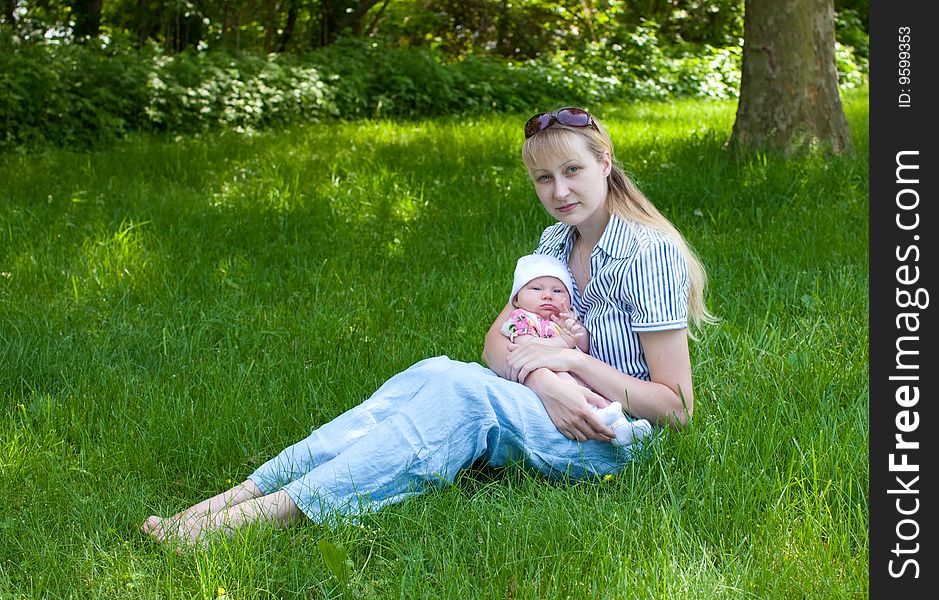 Baby And Mother Sitting In The Grass