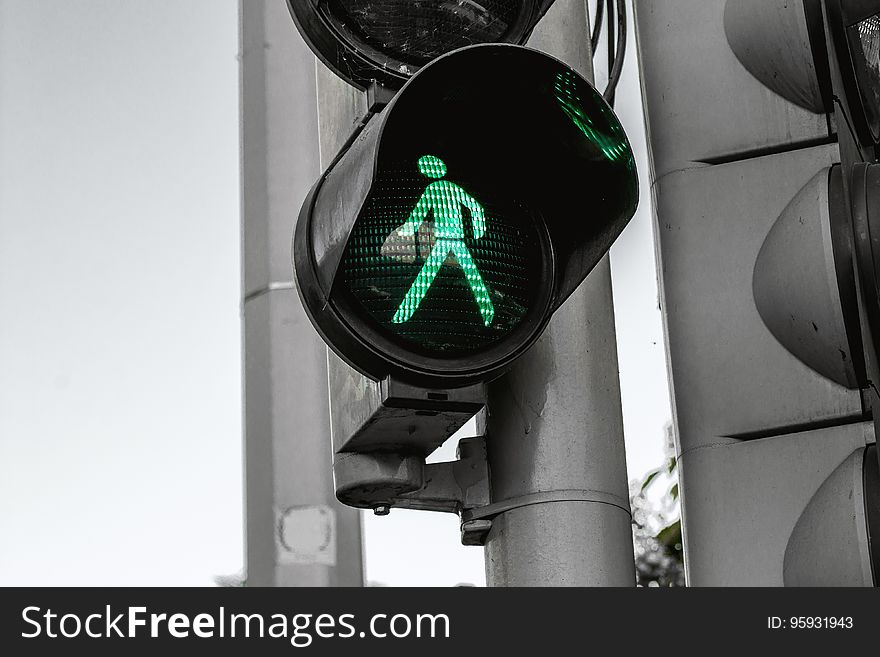 A traffic light with a green light for the pedestrians. A traffic light with a green light for the pedestrians.
