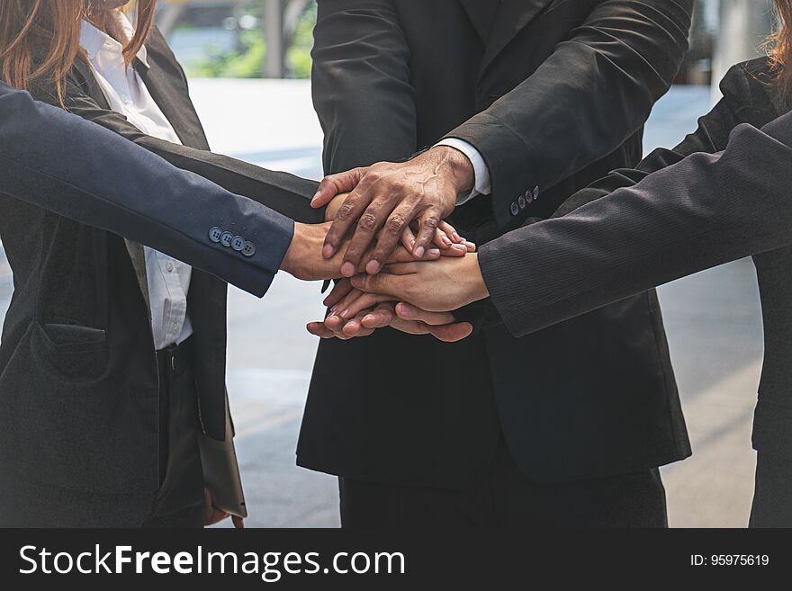 Group of business people joining hands.