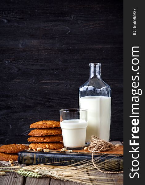 A pile of cookies with a bottle of milk and a glass of milk. A pile of cookies with a bottle of milk and a glass of milk.