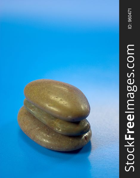 Three pebbles on blue background. Three pebbles on blue background