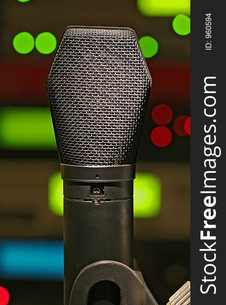 A condenser microphone with equipment LED's in the background