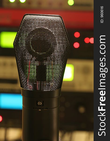 A condenser microphone with equipment LED's in the background. See through grill. A condenser microphone with equipment LED's in the background. See through grill.