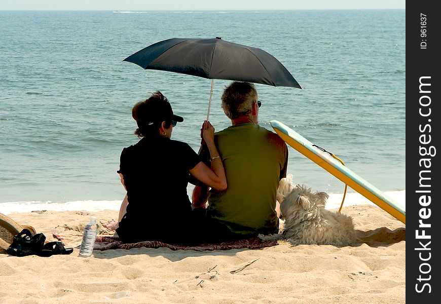 Couple on beach with black umbrella. Couple on beach with black umbrella
