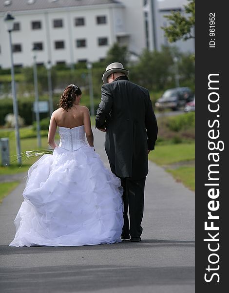 A wedding, bride and groom walking leisurely away from camera. A wedding, bride and groom walking leisurely away from camera