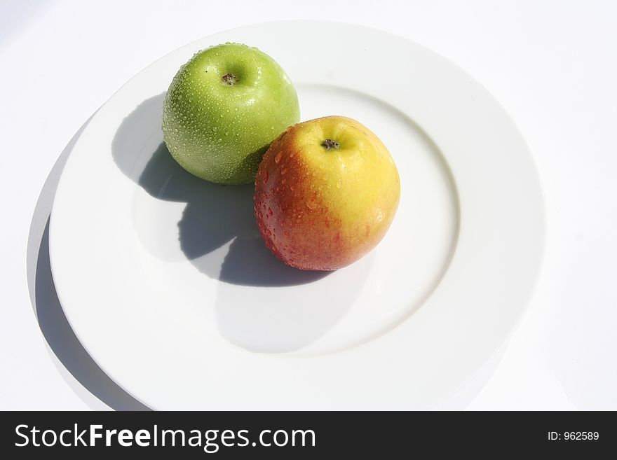 Two apples on a white plate. Two apples on a white plate