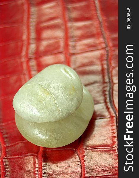 Two pebbles on red leather background. Two pebbles on red leather background