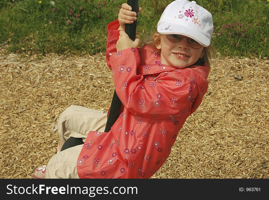 Child swinging from a playground frame.