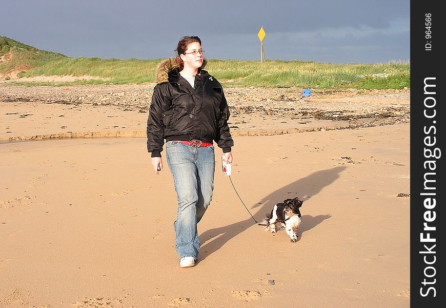 A young teenager walking a dog. A young teenager walking a dog.