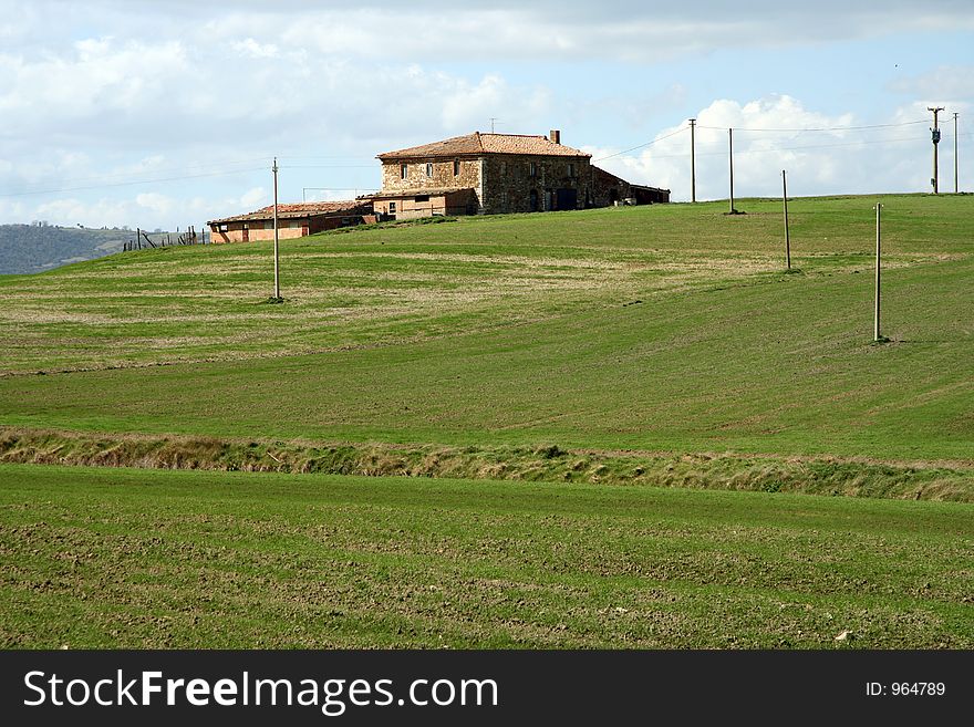 House and electric poles in agriculture landscape in Tuscany, Italy. House and electric poles in agriculture landscape in Tuscany, Italy.