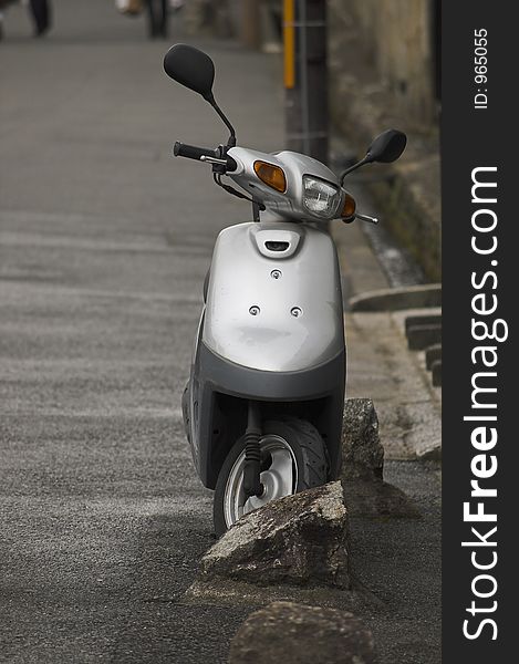 Silver scooter parked on street