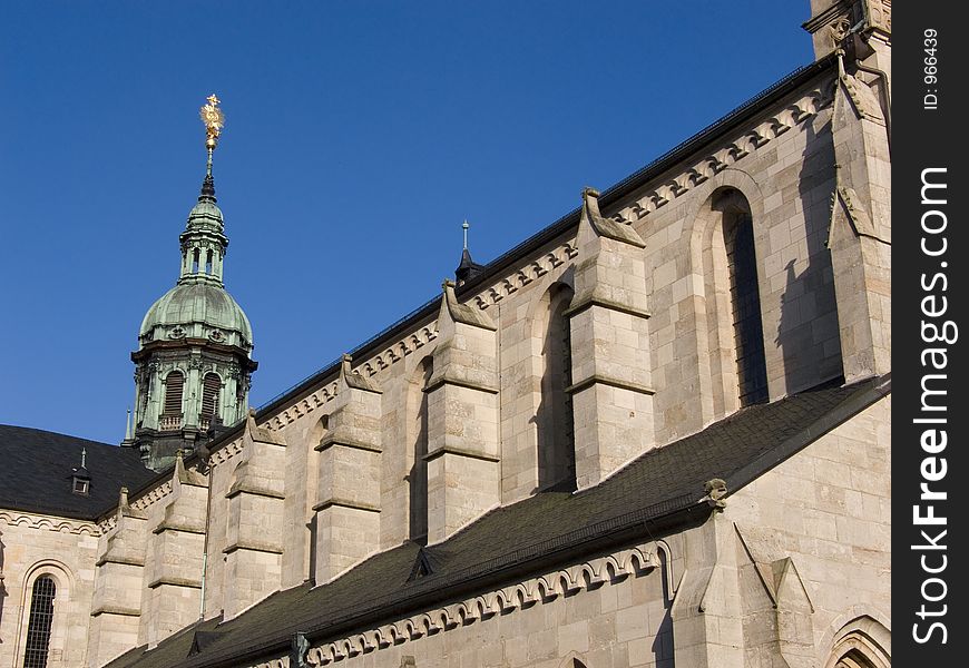 Roof of a cloister church in germany with a golden tower top