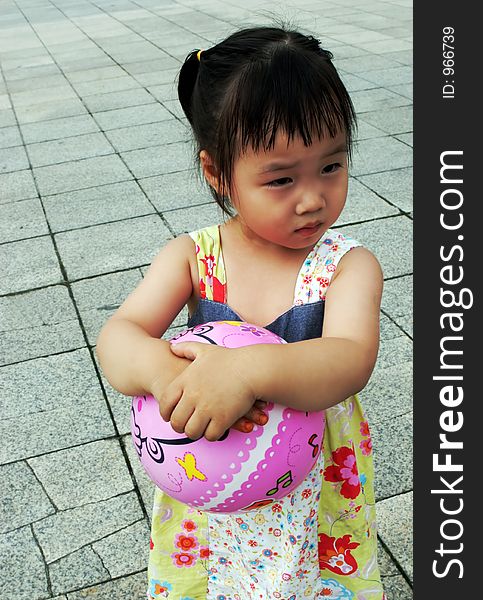 Cute Asian girl holding a ball