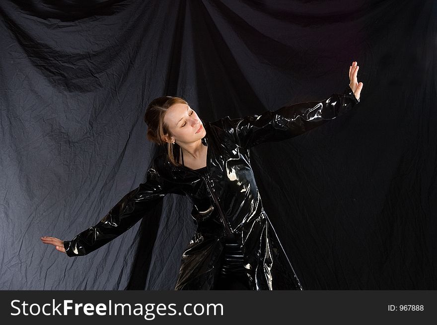 A dancer posed in a jazz pose, costumed in black vinyl. A dancer posed in a jazz pose, costumed in black vinyl