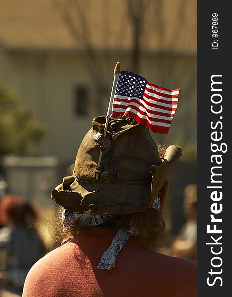 An american cowboy with an American flag attached to his leather hat. 4th of july.