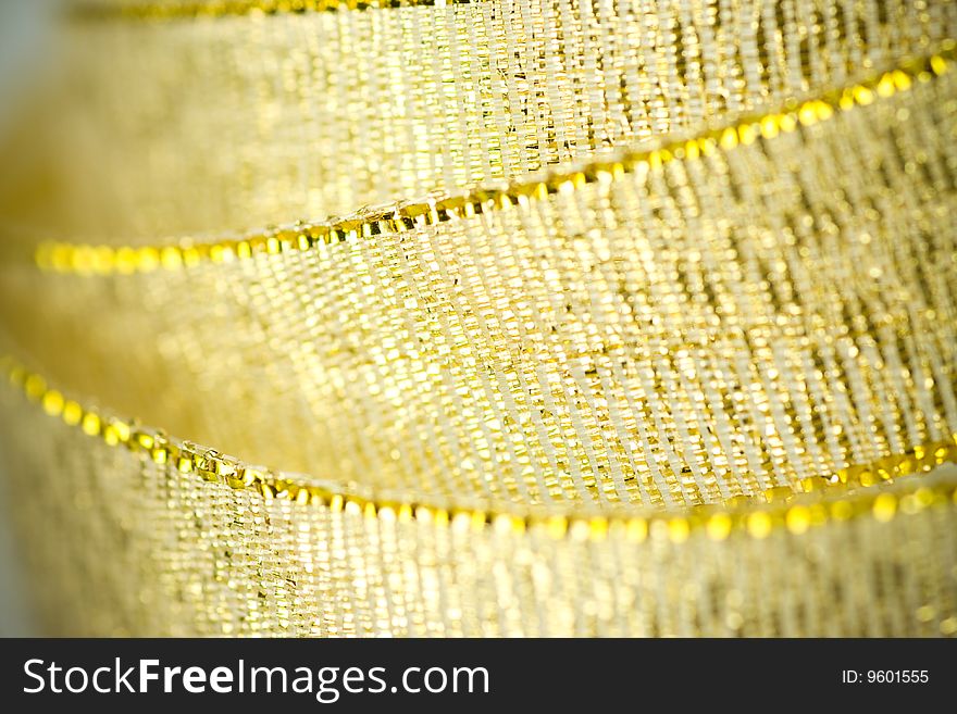 Ribbon in gold color, close up shot with selective soft focus.